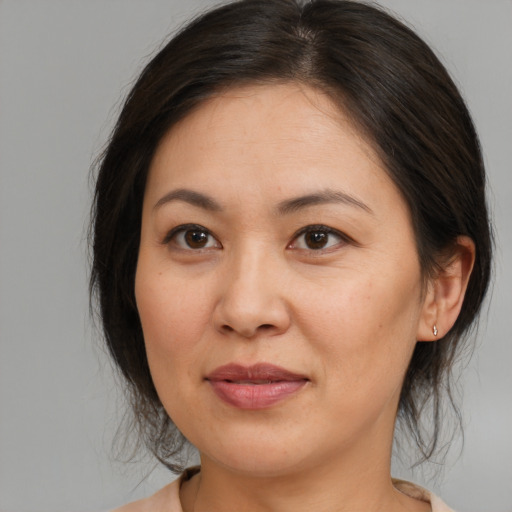 Joyful asian adult female with medium  brown hair and brown eyes