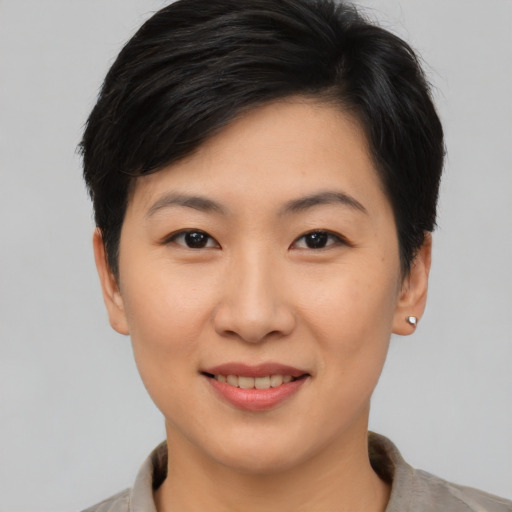 Joyful asian young-adult female with short  brown hair and brown eyes