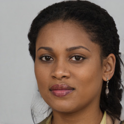 Joyful black young-adult female with long  brown hair and brown eyes