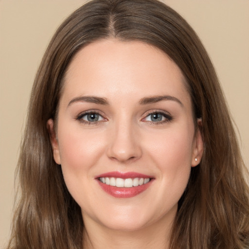 Joyful white young-adult female with long  brown hair and brown eyes