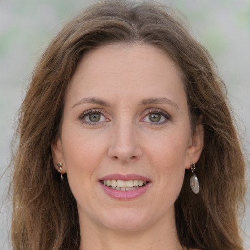 Joyful white adult female with long  brown hair and grey eyes