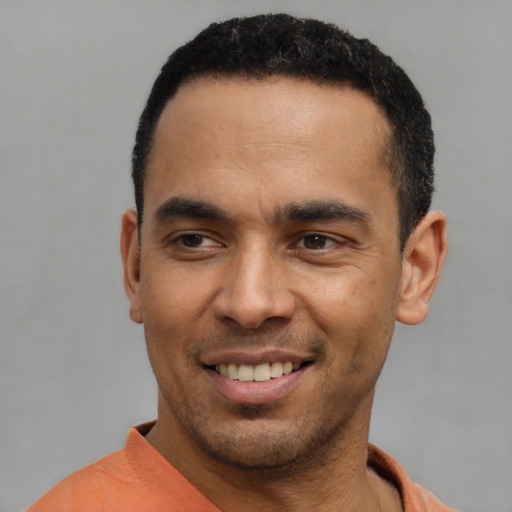 Joyful latino young-adult male with short  black hair and brown eyes