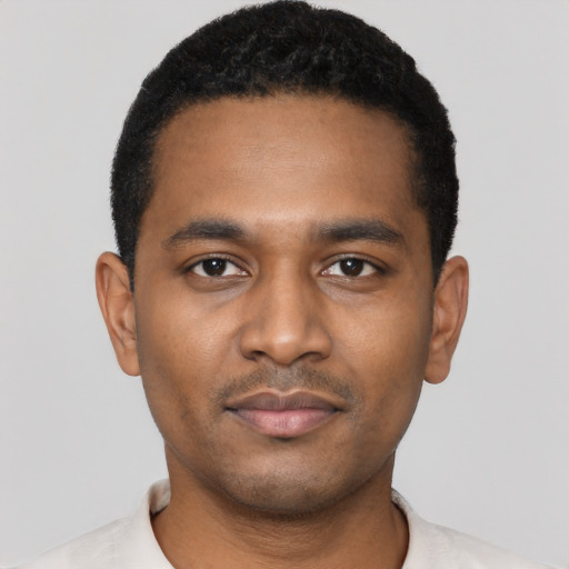 Joyful black young-adult male with short  black hair and brown eyes