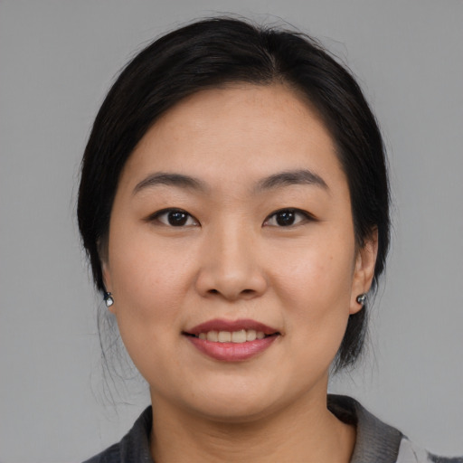 Joyful asian young-adult female with medium  black hair and brown eyes