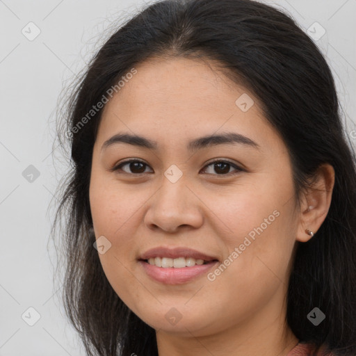 Joyful latino young-adult female with long  brown hair and brown eyes