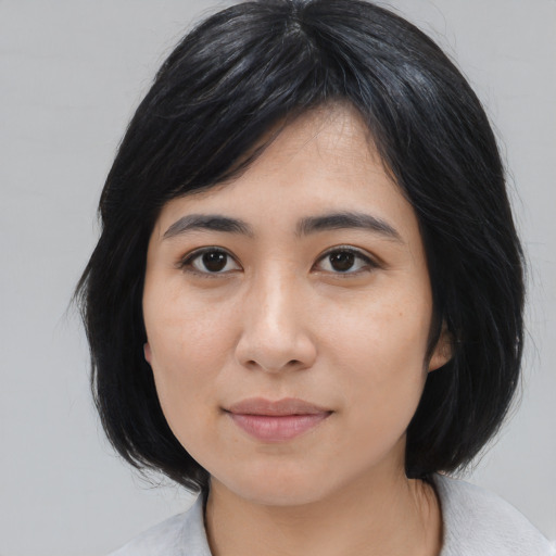 Joyful asian young-adult female with medium  black hair and brown eyes
