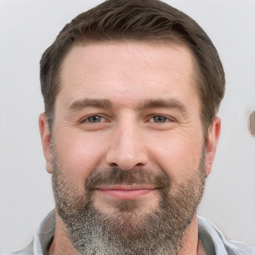 Joyful white adult male with short  brown hair and grey eyes