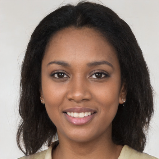 Joyful black young-adult female with long  brown hair and brown eyes
