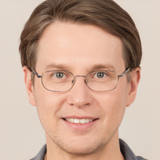 Joyful white adult male with short  brown hair and grey eyes