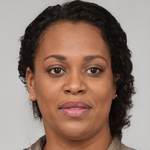 Joyful black adult female with medium  brown hair and brown eyes
