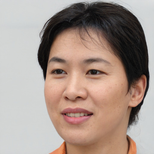 Joyful asian young-adult female with short  brown hair and brown eyes