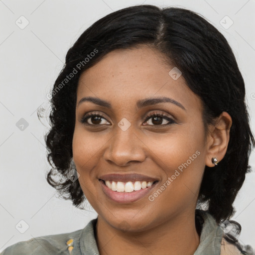 Joyful black young-adult female with long  brown hair and brown eyes