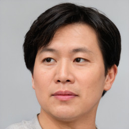 Joyful asian adult male with short  brown hair and brown eyes