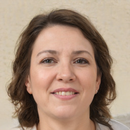 Joyful white adult female with medium  brown hair and brown eyes