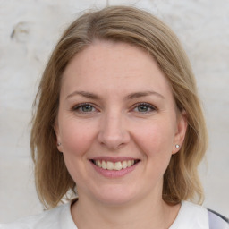 Joyful white young-adult female with medium  brown hair and blue eyes