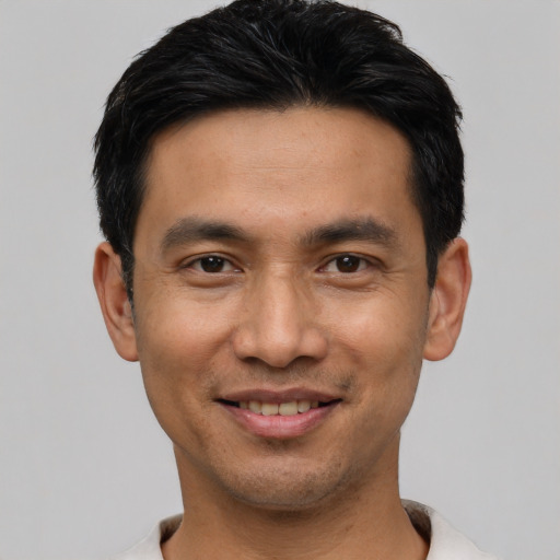 Joyful asian young-adult male with short  black hair and brown eyes