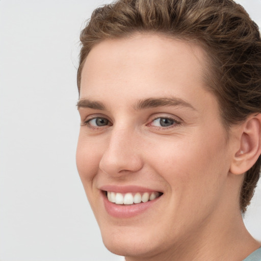 Joyful white young-adult female with short  brown hair and grey eyes