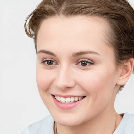 Joyful white young-adult female with short  brown hair and blue eyes