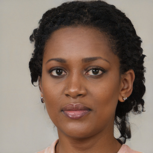 Joyful black young-adult female with medium  black hair and brown eyes
