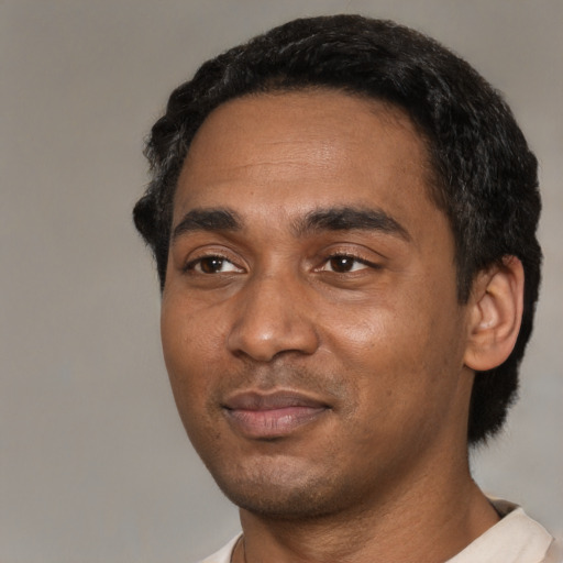Joyful black young-adult male with short  black hair and brown eyes