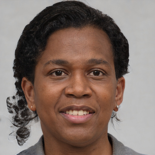Joyful black adult female with short  brown hair and brown eyes