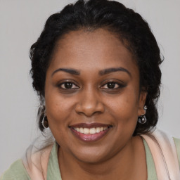 Joyful black adult female with long  brown hair and brown eyes