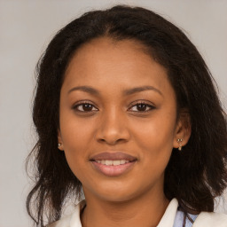 Joyful black young-adult female with long  brown hair and brown eyes