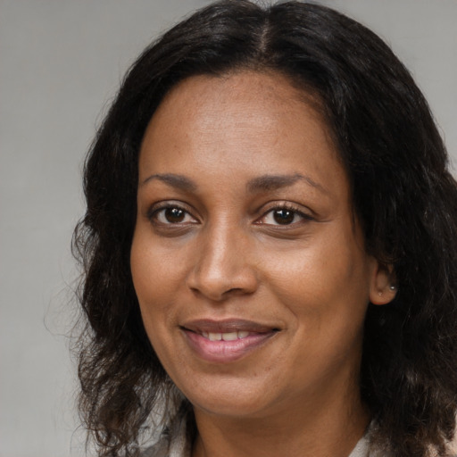 Joyful black adult female with long  brown hair and brown eyes