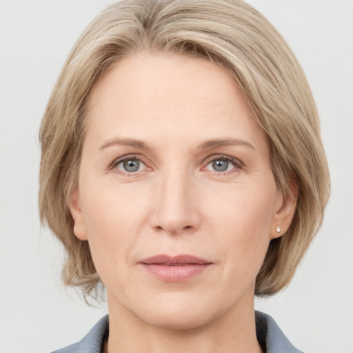 Joyful white adult female with medium  brown hair and grey eyes