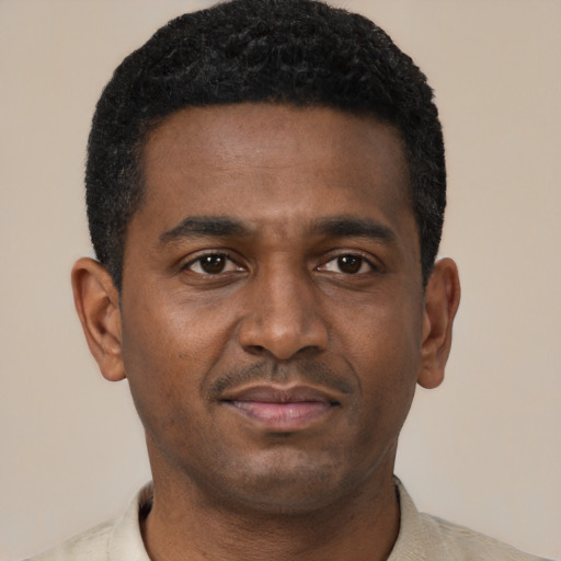 Joyful black young-adult male with short  black hair and brown eyes