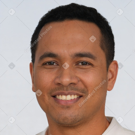 Joyful latino young-adult male with short  black hair and brown eyes