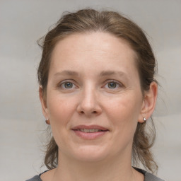 Joyful white adult female with medium  brown hair and grey eyes