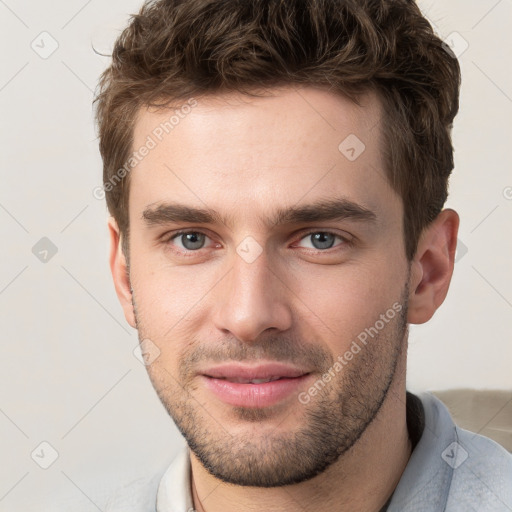 Joyful white young-adult male with short  brown hair and grey eyes