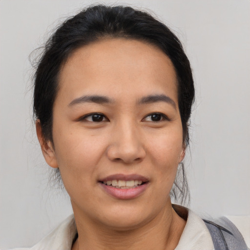 Joyful latino young-adult female with short  black hair and brown eyes