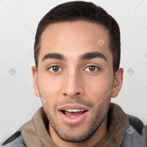 Joyful white young-adult male with short  black hair and brown eyes