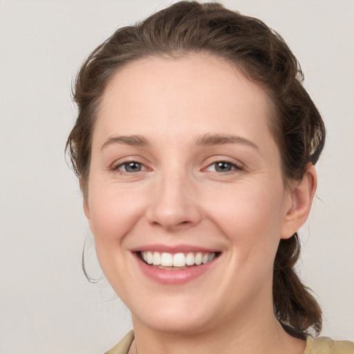 Joyful white young-adult female with medium  brown hair and grey eyes