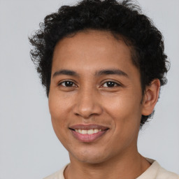 Joyful latino young-adult male with short  brown hair and brown eyes