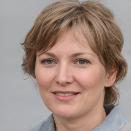 Joyful white adult female with medium  brown hair and grey eyes