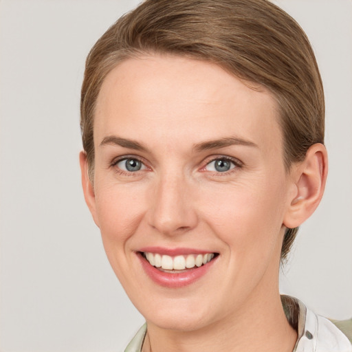 Joyful white young-adult female with short  brown hair and blue eyes