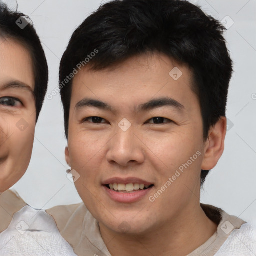 Joyful asian young-adult male with short  brown hair and brown eyes