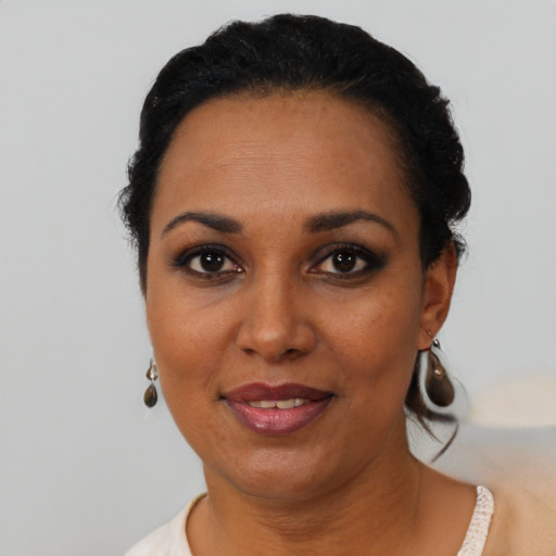 Joyful black young-adult female with short  black hair and brown eyes