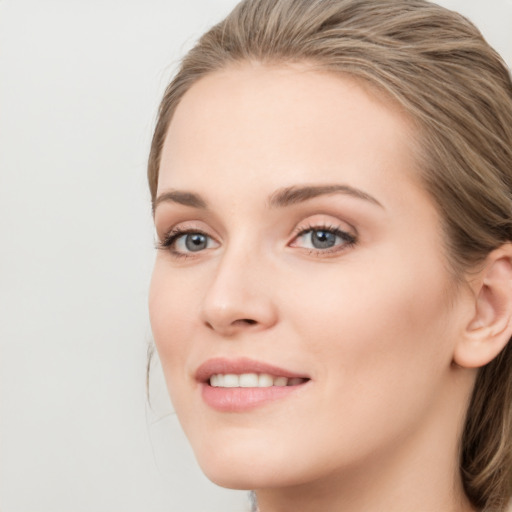 Joyful white young-adult female with long  brown hair and blue eyes