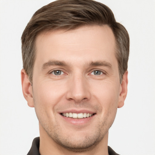 Joyful white young-adult male with short  brown hair and grey eyes