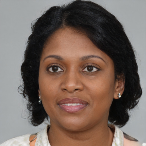 Joyful black young-adult female with medium  brown hair and brown eyes
