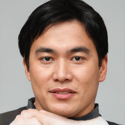 Joyful asian young-adult male with short  black hair and brown eyes