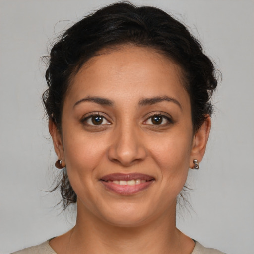 Joyful latino adult female with medium  brown hair and brown eyes