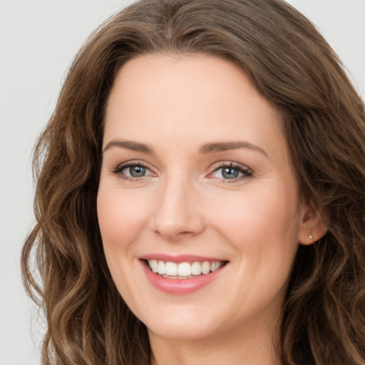 Joyful white young-adult female with long  brown hair and green eyes