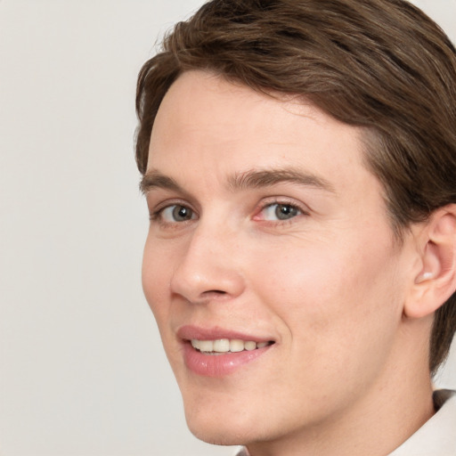 Joyful white young-adult male with medium  brown hair and grey eyes