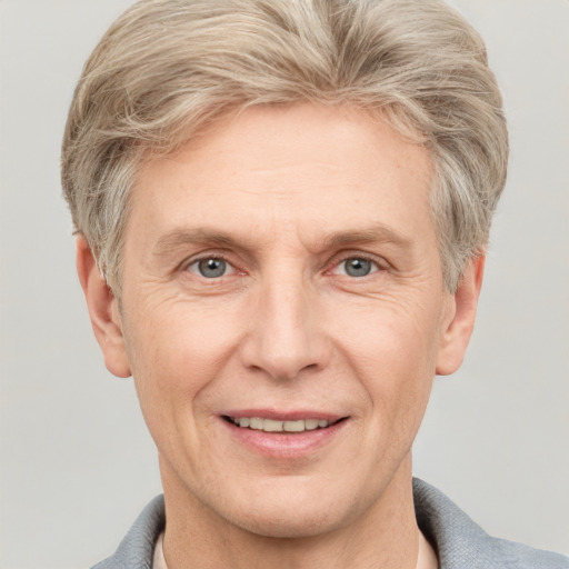 Joyful white adult male with short  blond hair and grey eyes