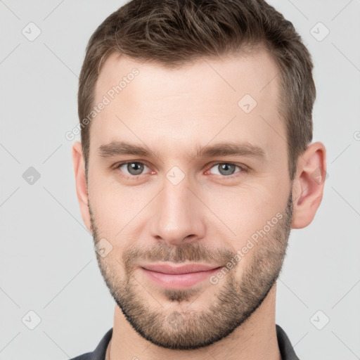 Joyful white young-adult male with short  brown hair and grey eyes